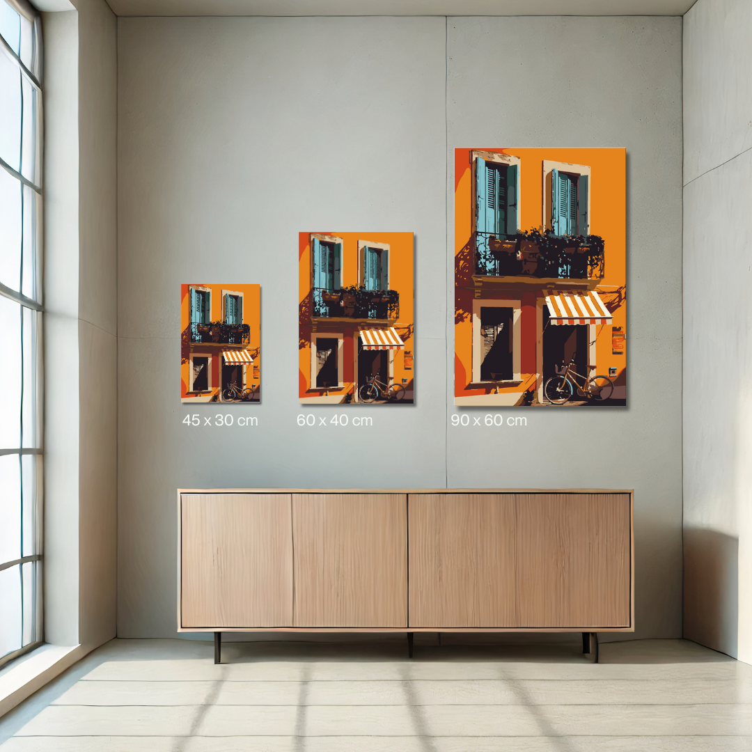 Malen-nach-Zahlen-Set 'Terracotta Balcony' mit mediterranem Stadtmotiv. Das Bild zeigt eine orangefarbene Fassade mit zwei blauen Fensterläden, einem Balkon mit Pflanzen und einer gestreiften Markise über einer Eingangstür. Ein Fahrrad lehnt an der Wand, während das Sonnenlicht warme Schatten wirft.